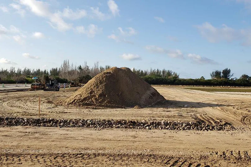 Graded vacant lot with a stockpile of dirt and a rock retaining wall