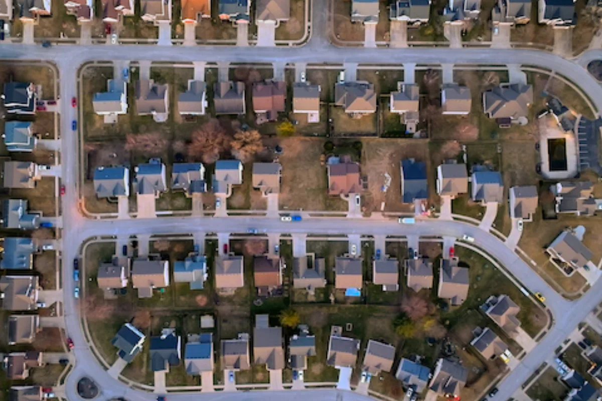 Aerial view of a residential neighborhood with houses, yards, and streets