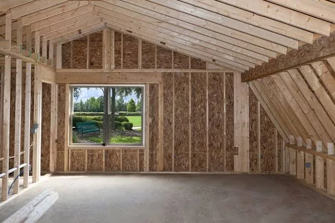 Wood stud walls and roof rafters inside a building under construction