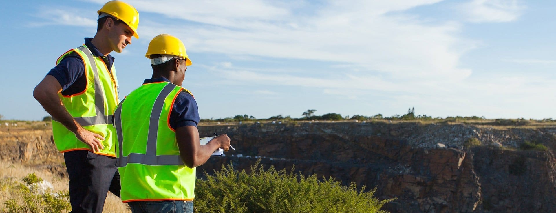 Surveyors reviewing terrain beyond a survey boundary
